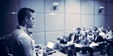 Public speaker giving talk at Business Event.
