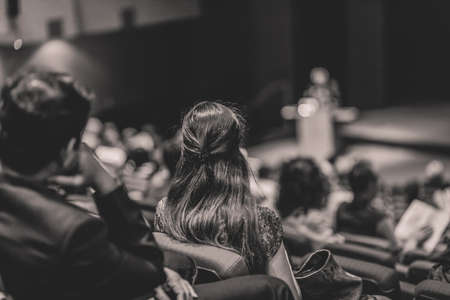 Business speaker giving a talk in conference hall.