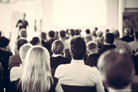 Speaker giving a talk in conference hall at business meeting event. Rear view of unrecognizable people in audience at the conference hall.の写真素材