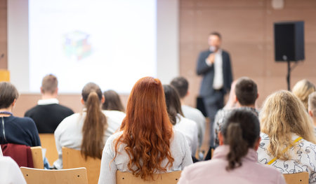 Speaker giving a talk in conference hall at business event. Rear view of unrecognizable people in audience at the conference hall. Business and entrepreneurship concept.の写真素材