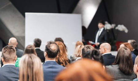 Speaker giving a talk in conference hall at business event. Rear view of unrecognizable people in audience at the conference hall. Business and entrepreneurship conceptの写真素材