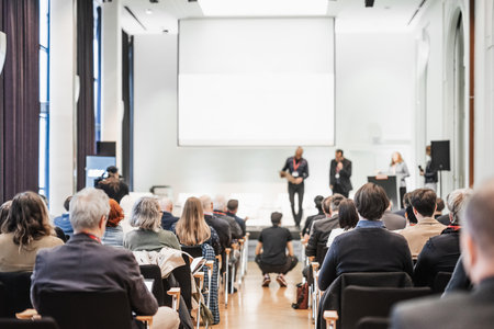 Business team leader receiving award prize at best business project competition event. Business and entrepreneurship award ceremony theme. Focus on unrecognizable people in audienceの写真素材
