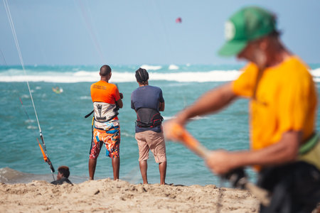 Active sporty people enjoying kitesurfing holidays and activities on perfect sunny day on Cabarete tropical sandy beach in Dominican Republicの写真素材