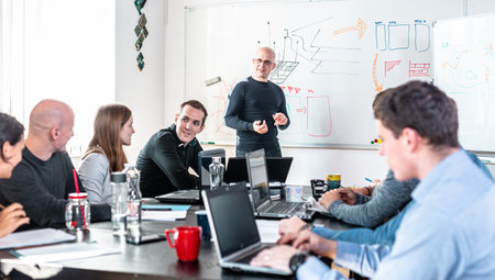 Relaxed informal IT business startup company meeting. Team leader discussing and brainstorming new approaches and ideas with colleagues. Startup business and entrepreneurship concept.の写真素材