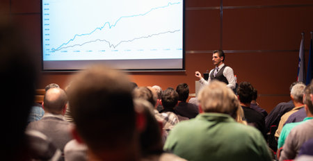 Speaker giving a talk in conference hall at business meeting event. Rear view of unrecognizable people in audience at the conference hall. Business and entrepreneurship concept.の写真素材