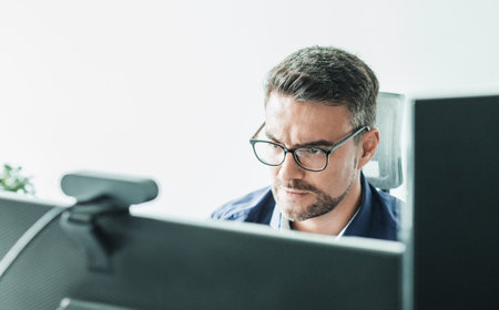 Remote work and modrn conectivity. Virtual meeting with many participents online. Webinar. Businessman talking online with employees via video connectionの写真素材