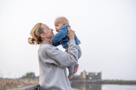 Tender woman caressing her little baby boy infant child outdoors on autumn trip to Secovlje salinas landscape park, Slovenia. Mothers unconditional love for her childの写真素材
