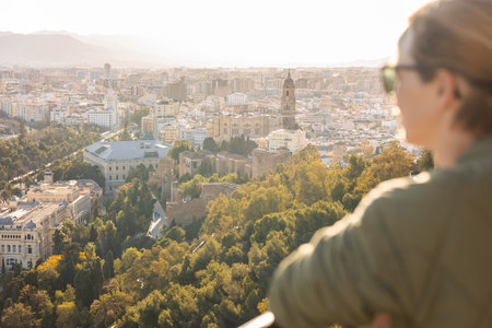 Bolnde female touris enjoying amazing panoramic aerial view of Malaga city historic center, Coste del Sol, Andalucia, Spain.の写真素材
