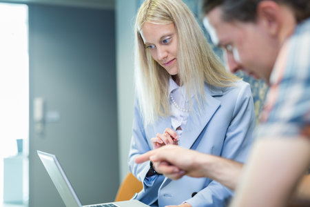 Business meeting. Client consulting. Confident business woman, real estate agent, financial advisor explaining details of project or financial product to client in officeの写真素材