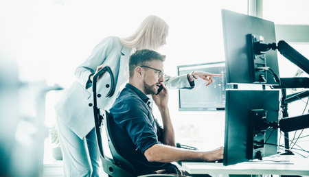 Stock broker business team trading online watching charts and data analyses on multiple computer screens in modern corporate work station office.の写真素材