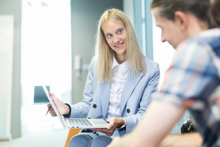 Business meeting. Client consulting. Confident business woman, real estate agent, financial advisor explaining details of project or financial product to client in officeの写真素材