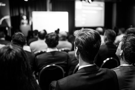 Speaker giving a talk in conference hall at business event. Rear view of unrecognizable people in audience at the conference hall. Business and entrepreneurship conceptの写真素材
