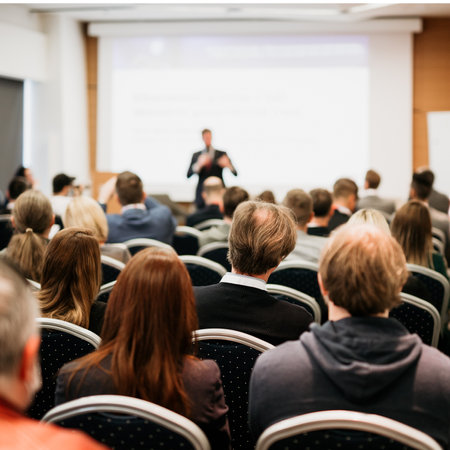 Speaker giving a talk in conference hall at business event. Rear view of unrecognizable people in audience at the conference hall. Business and entrepreneurship conceptの写真素材