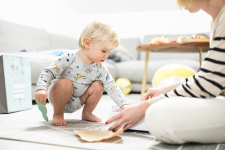 Parents playing games with child. Little toddler doing puzzle. Infant baby boy learns to solve problems and develops cognitive skills. Child development concept.の写真素材