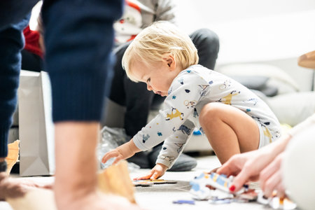 Parents playing games with child. Little toddler doing puzzle. Infant baby boy learns to solve problems and develops cognitive skills. Child development concept.の写真素材
