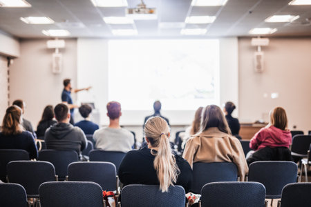 Speaker giving a talk in conference hall at business event. Rear view of unrecognizable people in audience at the conference hall. Business and entrepreneurship conceptの写真素材