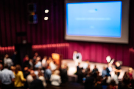 Blured image of Business and entrepreneurship symposium. Female speaker giving a talk at business meeting. Audience in conference hall. Rear view of unrecognized participant in audience.の写真素材