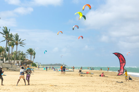 Crowd of active sporty people enjoying kitesurfing holidays and activities on perfect sunny day on Cabarete tropical sandy beach in Dominican Republicの写真素材