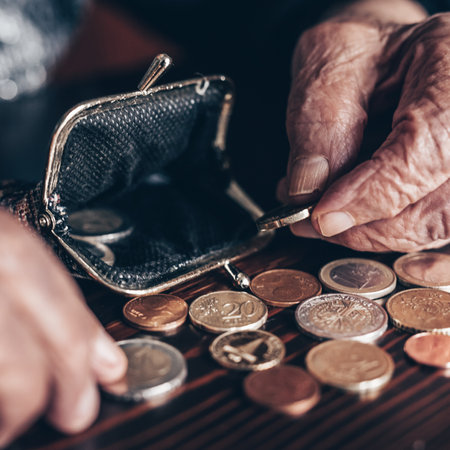 Detailed closeup photo of elderly 96 years old womans hands counting remaining coins from pension in...