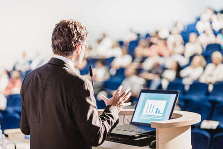 Speaker at Business Conference with Public Presentations. Audience at the conference hall. Entrepreneurship club. Rear view. Horisontal composition. Background blur.の写真素材