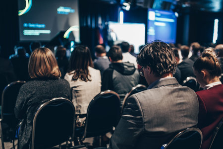 Speaker giving a talk in conference hall at business event. Rear view of unrecognizable people in audience at the conference hall. Business and entrepreneurship conceptの写真素材