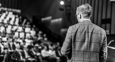 Speaker giving a talk on corporate business conference. Unrecognizable people in audience at conference hall. Business and Entrepreneurship event. Black and white image.の写真素材
