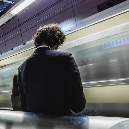 Passengers traveling by Tokyo metro. Business people commuting to work by public transport in rush hour. Shallow depth of field photo.の写真素材