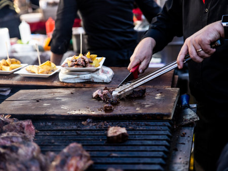 Some excellent pieces of Argentinian beef on a charcoal grill being prepared at open kitchen street food festival in Ljubljana, Sloveniaの写真素材
