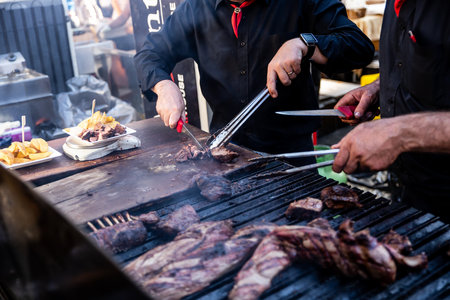 Some excellent pieces of Argentinian beef on a charcoal grill being prepared at open kitchen street food festival in Ljubljana, Sloveniaの写真素材