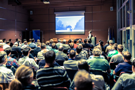 Speaker giving a talk in conference hall at business meeting event. Rear view of unrecognizable...