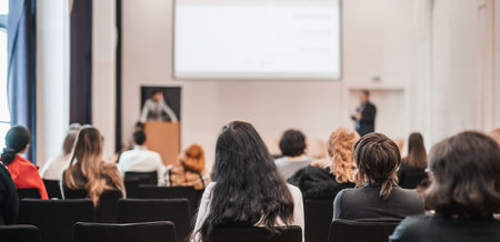 Speaker giving a talk in conference hall at business event. Rear view of unrecognizable people in audience at the conference hall. Business and entrepreneurship conceptの写真素材