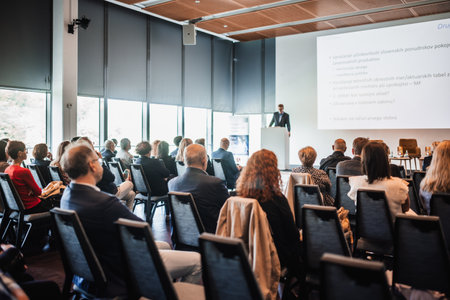 Speaker giving a talk in conference hall at business event. Rear view of unrecognizable people in audience at the conference hall. Business and entrepreneurship conceptの写真素材