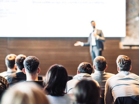 Speaker giving a talk in conference hall at business event. Rear view of unrecognizable people in audience at the conference hall. Business and entrepreneurship conceptの写真素材