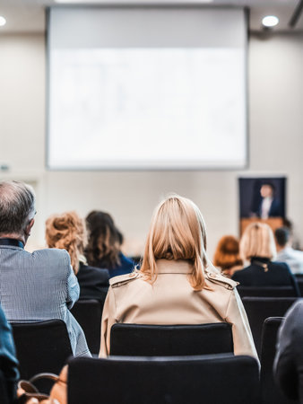 Speaker giving a talk in conference hall at business event. Rear view of unrecognizable people in audience at the conference hall. Business and entrepreneurship conceptの写真素材