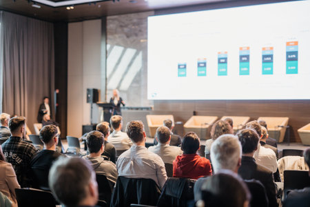 Speaker giving a talk in conference hall at business event. Rear view of unrecognizable people in audience at the conference hall. Business and entrepreneurship conceptの写真素材