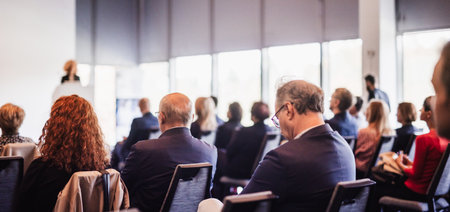 Business and entrepreneurship symposium. Female speaker giving a talk at business meeting. Audience...
