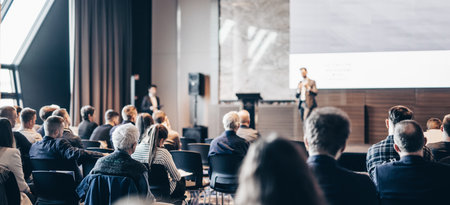 Speaker giving a talk in conference hall at business event. Rear view of unrecognizable people in audience at the conference hall. Business and entrepreneurship conceptの写真素材
