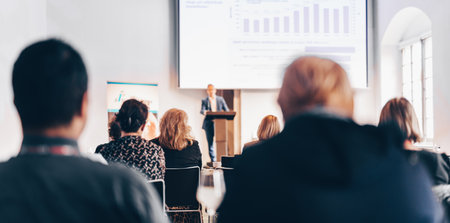 Speaker giving a talk in conference hall at business event. Rear view of unrecognizable people in audience at the conference hall. Business and entrepreneurship conceptの写真素材