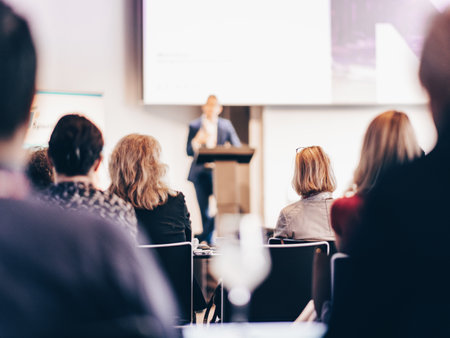 Speaker giving a talk in conference hall at business event. Rear view of unrecognizable people in audience at the conference hall. Business and entrepreneurship conceptの写真素材