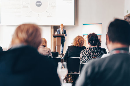 Speaker giving a talk in conference hall at business event. Rear view of unrecognizable people in audience at the conference hall. Business and entrepreneurship conceptの写真素材