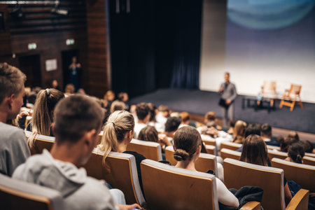 Speaker giving a talk in conference hall at business event. Rear view of unrecognizable people in audience at the conference hall. Business and entrepreneurship conceptの写真素材