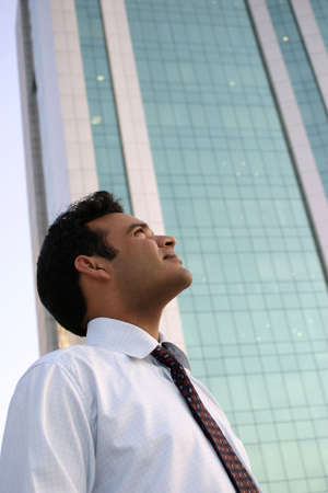 Young Man Looking Up at a highrise building with dreams in his eyesの写真素材