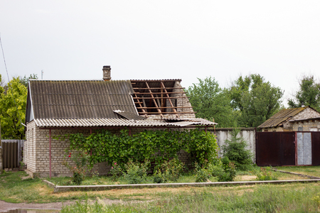 broken roof after a hurricane, a house in the village, the destroyed roof of a residential houseの写真素材