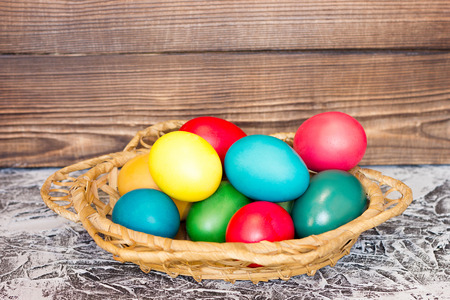 basket with Easter eggs on the background of wooden boards, the concept for the holiday Easterの写真素材