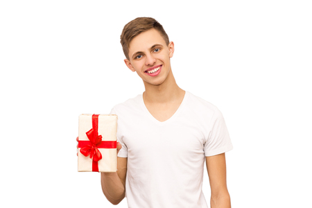 portrait of a guy with a gift, isolate, the guy in a white T-shirt gives a giftの写真素材