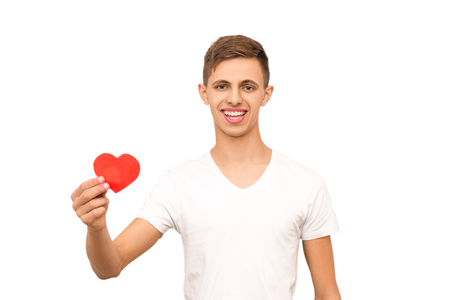the guy in the white T-shirt holds the heart, isolate, the man congratulates the man of the female sexの写真素材