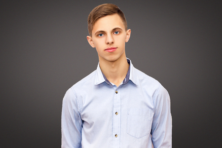 portrait of a guy on a black studio background, calm man in a blue shirtの写真素材