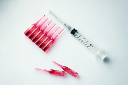 Syringes with.Medical vials for injection with a syringe and ampules on blue background.  Medicine...