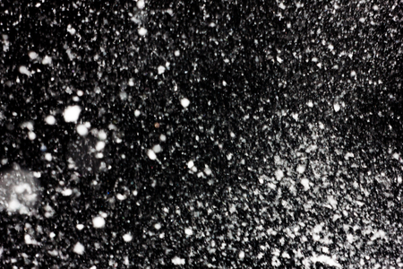 white snow falls on the black sky. Snowstorm on a black background. In isolation. heavy snowfall.  drifts. severe winter.the texture is heavy snowfall on a black backgroundの写真素材