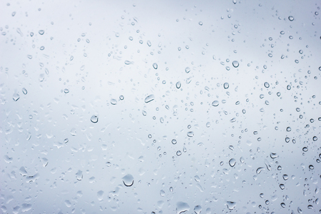 water drops on the glass with a blue tint, the texture of water drops, water backgroundの写真素材